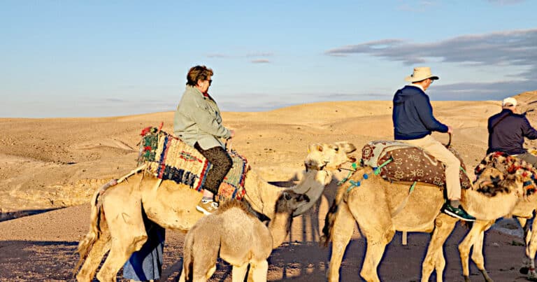 Travelers enjoy a camel ride through the stunning Agafay Desert near Marrakech, Morocco.