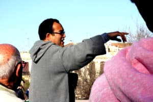 Abdellatif Bougoula, founder of Morocco Travel Experience, passionately explains the history of a landmark in Tangier to a group of travelers.